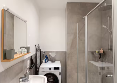 modernes Bad mit XXL Regendusche, Waschmaschine, helles Licht, Haartrockner, Hygieneartikel wie Shampoo und Duschgel