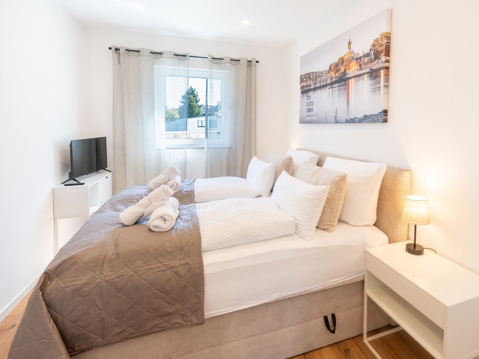 Separates Schlafzimmer mit Doppelbett und Smart-TV im Studio Mosella
