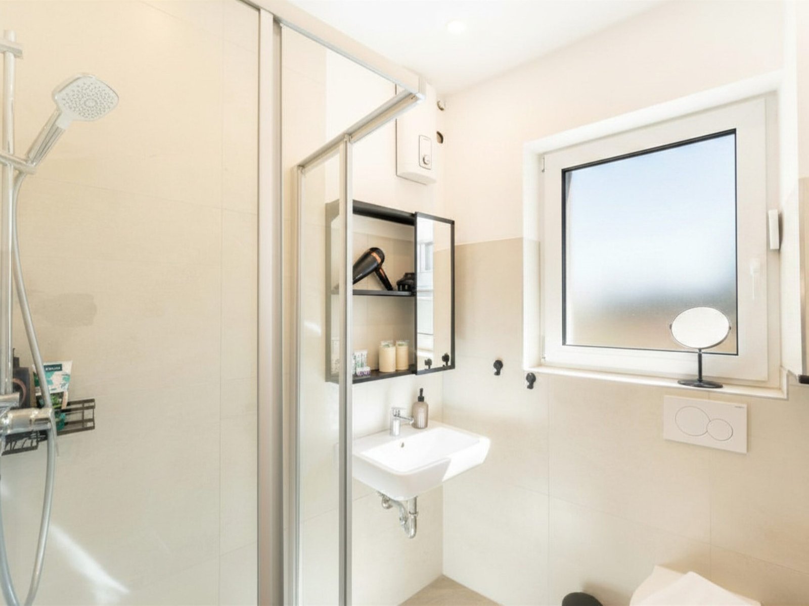 Helles Badezimmer mit Dusche und Fenster im Studio Rhena