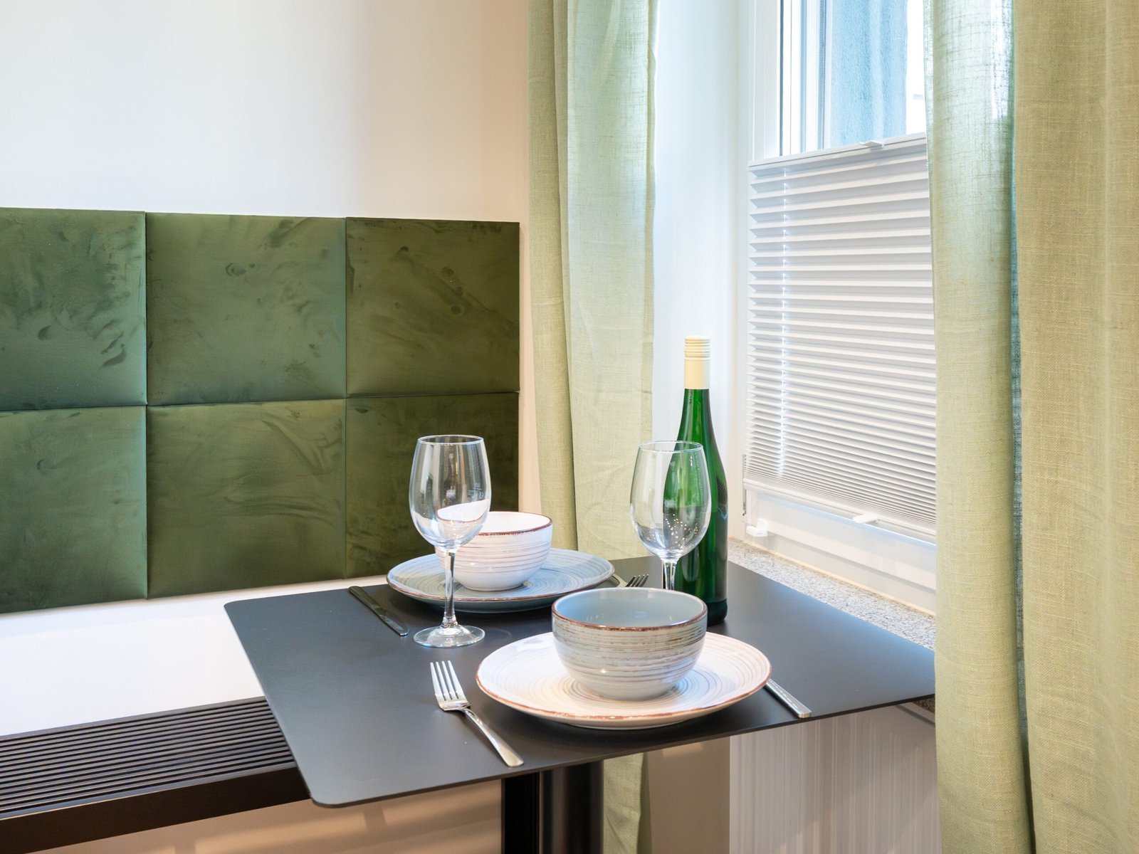 Essplatz am Fenster mit grüner Sitzbank im Studio Rhena